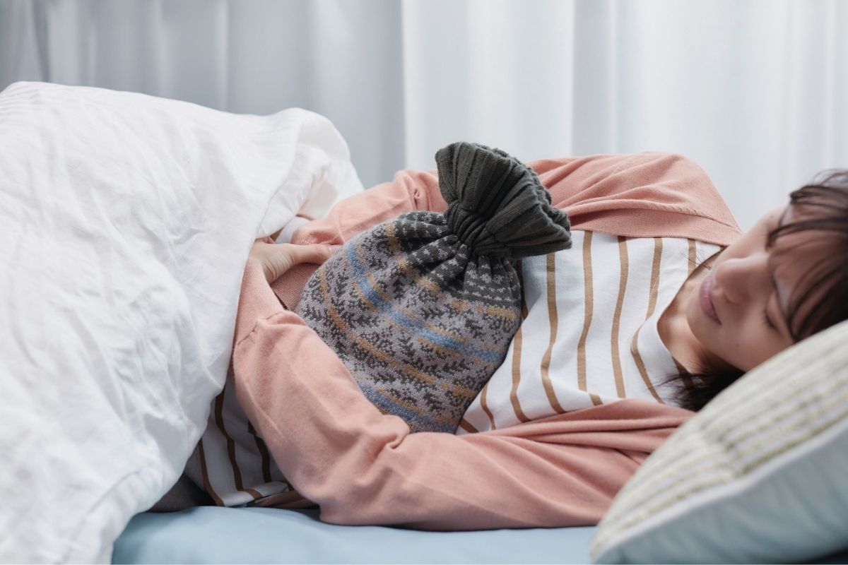 Doktorandin mit Wärmflasche im Bett